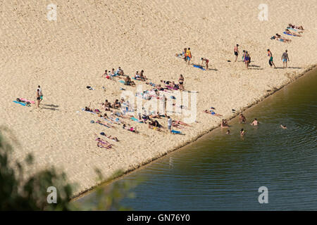 Foule de touristes de détente sur le sable de percuteur sandblow et la natation dans les eaux sombres du lac Wabby sur Fraser Island Australie Banque D'Images