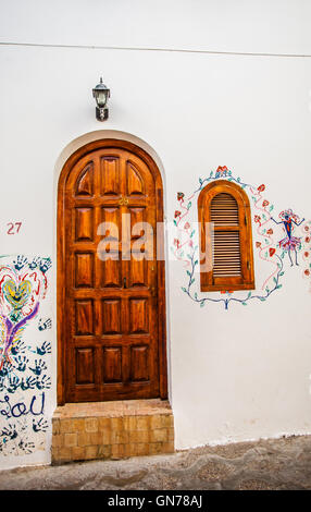 Porte en bois massif avec fenêtre fermée sur un mur peint en blanc Banque D'Images