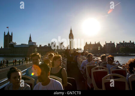 Les touristes en bus à toit ouvert à la recherche de Big Ben à l'extrémité nord du Palais de Westminster à Londres en été avec ciel bleu Banque D'Images