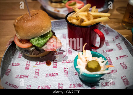 Fromage et bacon burger avec frites et salade de choux servi dans le restaurant Hucks Banque D'Images