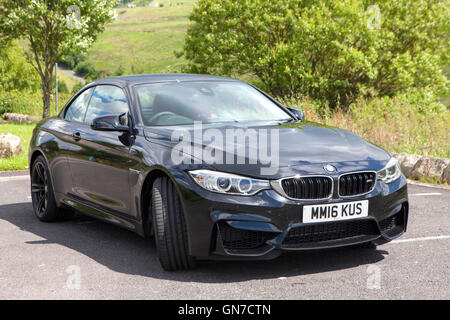 F83 BMW M4 Cabriolet Noir 2 portes coupé avec du cuir rouge garée dans la campagne en été Banque D'Images