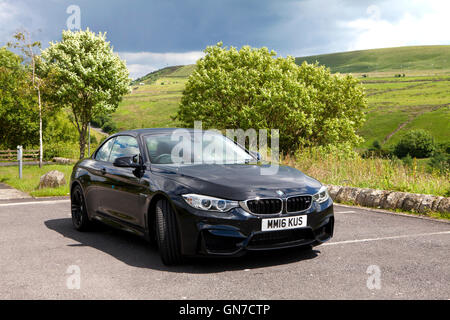 F83 BMW M4 Cabriolet Noir 2 portes coupé avec du cuir rouge garée dans la campagne en été Banque D'Images