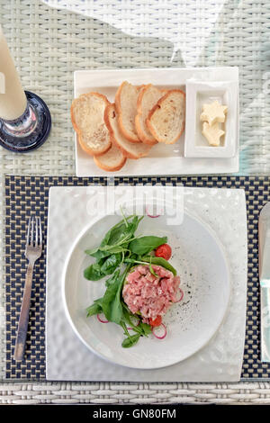 Plat de salade de thon et d'avocat salade de roquette à l'embellissement. Banque D'Images