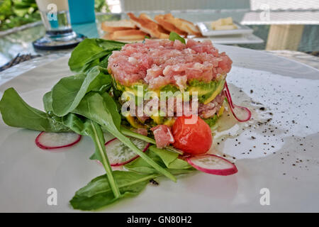 Plat de salade de thon et d'avocat salade de roquette à l'embellissement. Banque D'Images