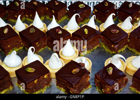 Pistache chocolat brownies avec du glaçage et citron crème anglaise tartes pâtisserie crème fouettée Banque D'Images