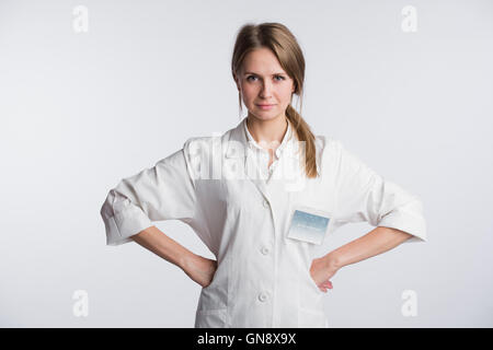 Portrait de femme médecin chirurgien en pose assurée isolated over white background with hands on hips Banque D'Images