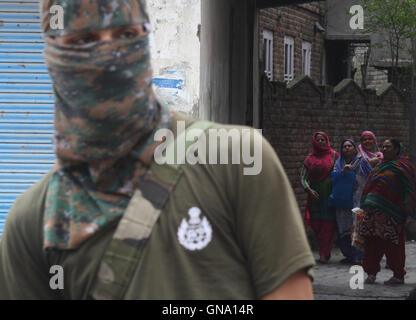 Srinagar, Cachemire indien:27.août.Une police indienne du Cachemire, en tant que garde les hommes comme femmes cachemiries traverser la route durant les affrontements avec les manifestants du Cachemire.compétentes a levé le couvre-feu après 52 jours d'isolement cellulaire au milieu de la violence mortelle, mais la rue des heurts ont éclaté entre manifestants et forces de sécurité. Restrictions ont été levées dans la majeure partie de la vallée du Cachemire dont la principale ville de Sringar "à la suite d'amélioration de la situation", a annoncé la police . Plus de 71 personnes ont été tuées et plus de 10000 blessés au cours du dernier mois et demi après les protestations sur le ki Banque D'Images