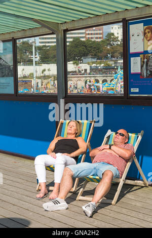 Bournemouth, Dorset, UK. Août 29, 2016. Couple de chaises longues sur la jetée de Bournemouth bénéficiant du soleil sur Bank Holiday lundi. Credit : Carolyn Jenkins/Alamy Live News Banque D'Images