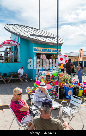 L'Angleterre, Ramsgate. Le long du front de mer port, foules bénéficiant d'août soleil et canicule. Des gens assis à des tables à l'extérieur d'un plateau/bouilloire. Grand angle de vue. Le bleu ciel nuageux. Banque D'Images