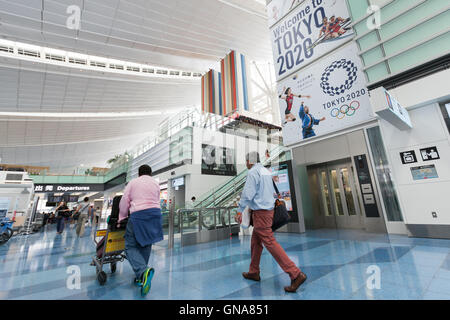 Les voyageurs devant une publicité Jeux Olympiques de Tokyo sur l'affichage à l'Aéroport International de Tokyo le 30 août 2016, Tokyo, Japon. Entre le 24 août et le 10 octobre, l'aéroport est afficher un grand nombre d'Bienvenue à Tokyo 2020 signe pour promouvoir les Jeux Olympiques d'été de 2020. © Rodrigo Reyes Marin/AFLO/Alamy Live News Banque D'Images