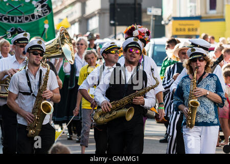 Les membres du groupe de jazz jouant saxophones en marchant et dirigeant le Boadstairs semaine folklorique défilé. Portant des costumes de la marine. Banque D'Images