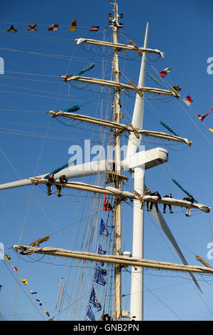 Blyth, Northumberland et de travail de l'équipage en altitude sur le brick polonais 'Chopin' contre un 128 mètres de haut, une éolienne. Banque D'Images