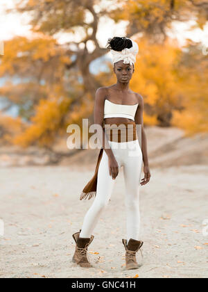 Portrait de jeune femme à la mode avec de longs cheveux tressés Wearing Head Wrap, petit top et Leggings Banque D'Images