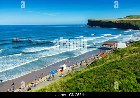 Des foules de gens profitant de Saltburn Pier et plage sur une rive ensoleillée Maison de Vacances Banque D'Images