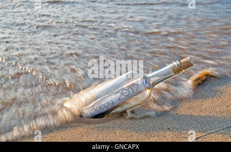 L'année 2017 nouveau message dans une bouteille sur la plage de sable. Banque D'Images