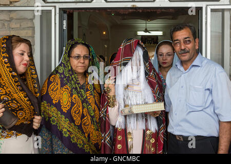 Bandar Torkaman, turkmène, Mariage mariée couverte de voile traditionnelle de quitter le lieu du déjeuner Banque D'Images