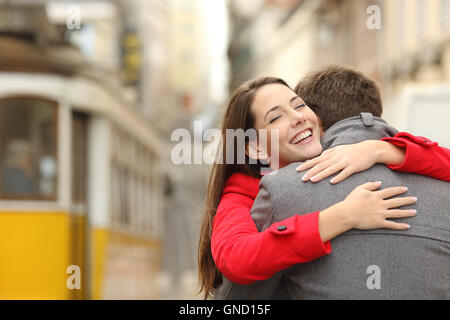 Rencontre d'un couple heureux dans l'amour dans la rue après un tram voyager dans un paysage coloré Banque D'Images