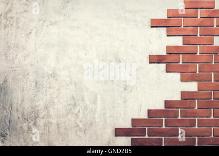 Vintage des briques rouges sur un mur en ciment poli. Banque D'Images