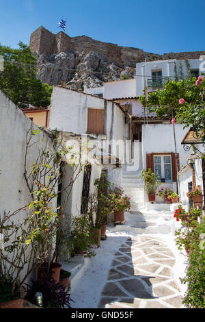 Rue romantique d'un quartier résidentiel de Plaka, construire dans le style grec traditionnel, sous la colline avec l'Acropole. Drapeau grec Banque D'Images