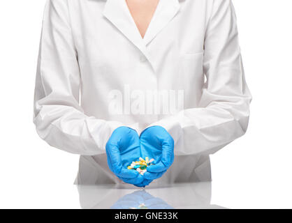Close up of female doctor en blanc et bleu robe médical gants chirurgicaux stérilisés holding pile de comprimés et capsules Banque D'Images