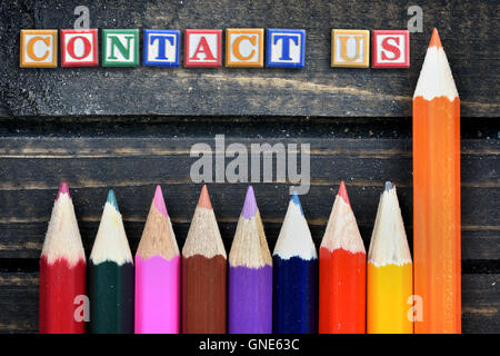 Contactez-nous texte et groupe de crayon sur table en bois Banque D'Images