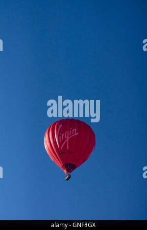 Bradley Stoke, UK. Août 30, 2016. Virgin Richard Branson, vols de ballon entreprise propose des excursions en montgolfière. Ce ballon rouge a été vu dans le soleil matinal sur Bradley Stoke près de Bristol d'aujourd'hui. Crédit : Mr Standfast/Alamy Vivre NewsLive News Banque D'Images