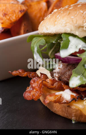Accueil gastronomique fait bacon cheeseburger sur fond en bois rustique Banque D'Images