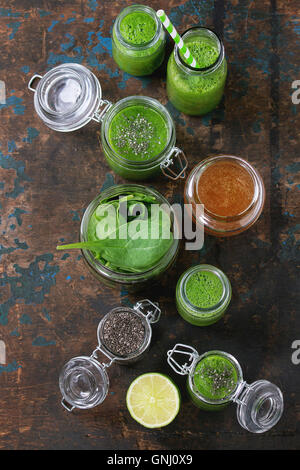 Ouvert en pots de verre et bouteille de smoothie vert épinards, servi avec des feuilles d'épinards, graines de chia, miel et citron plus vieux woo Banque D'Images