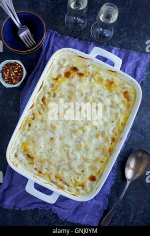 Artichauts crémeux Mac 'N' Cheese dans un plat de cuisson en céramique blanche en haut d'un violet/bleu linin serviette. Photographié en vue de dessus o Banque D'Images