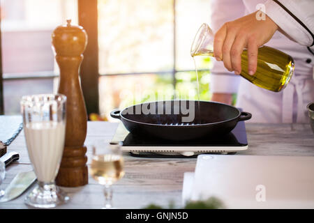 Verse un liquide sur poêle. Banque D'Images