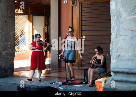 Bologne, Italie - Juillet 2016 : des musiciens de rue avec une chanteuse, violon et guitare sur un carré à Bologne en Italie jouant pour l'argent Banque D'Images