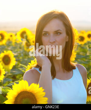 Femme en champ de tournesol au coucher du soleil Banque D'Images