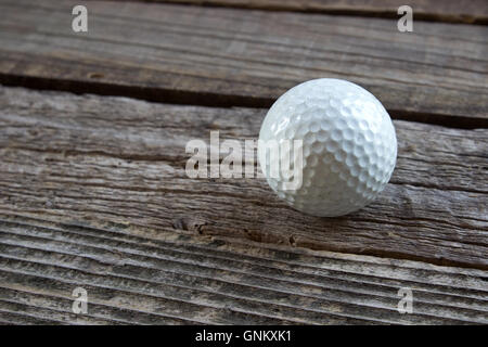 Vieille balle de golf sur fond de bois