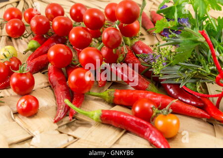 Poivrons rouges et tomates cerises fraîches sur fond de bois Banque D'Images