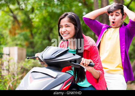 2 Jeune fille et garçon Park Riding Amis Scooty profiter Banque D'Images