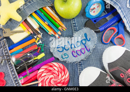 School is Cool signer avec des objets d'apprentissage créatif sur les blue-jeans Banque D'Images