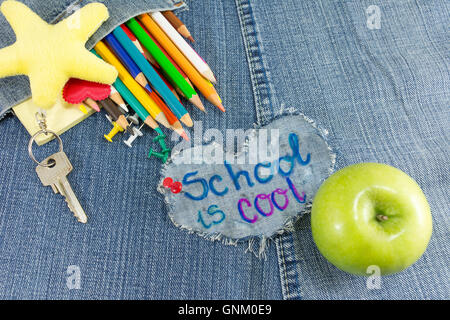 School is Cool signer avec des objets d'apprentissage créatif sur les blue-jeans Banque D'Images