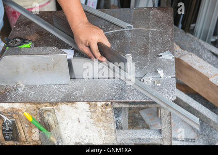 Un homme d'utiliser la machine pour couper l'aluminium. Banque D'Images