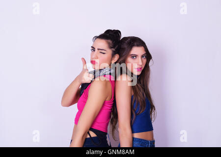 Portrait de deux belles femmes qui posent. Concept d'amitié. Amis mode et élégant, plus isolé sur fond gris. Banque D'Images