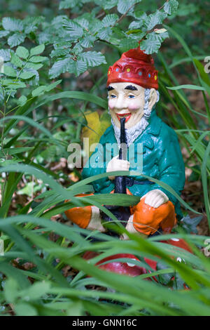 Jeu de jardin une flûte assis sur un tabouret de crapaud dans le jardin Banque D'Images