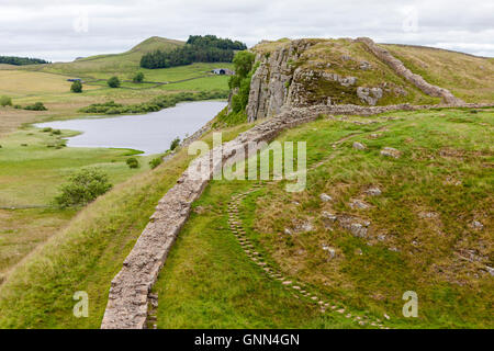 Northumberland, England, UK. Peel Crags de Steel Rigg, mur d'Hadrien, sentier pédestre. Crag Lough sur la gauche. Banque D'Images