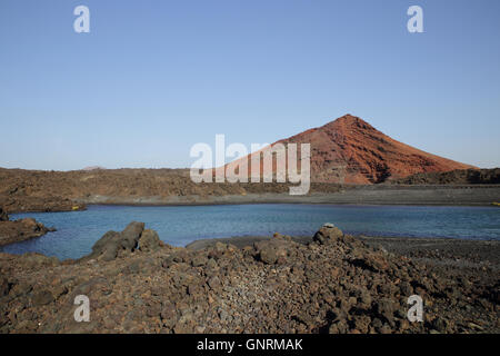 Aperçu d'un petit lac dans la lave près de Playa Bermeja en face d'un vulcain de Parc National de Timanfaya, Banque D'Images