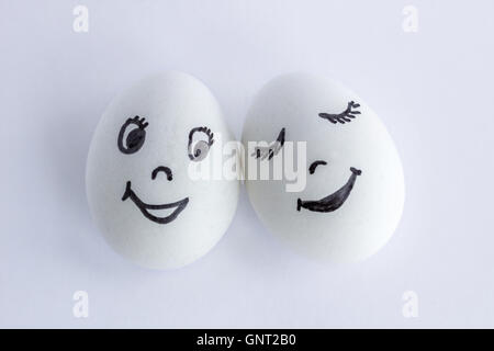 Funny oeufs blancs imitant un couple d'amoureux souriant heureux sur fond blanc Banque D'Images