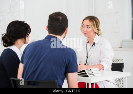 Médecin et jeune couple patients at office Banque D'Images