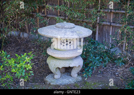 Une lanterne japonaise traditionnelle en pierre entourée de bambous et de verdure au Jardin de l'Amitié japonaise du Balboa Park à San Diego. Banque D'Images