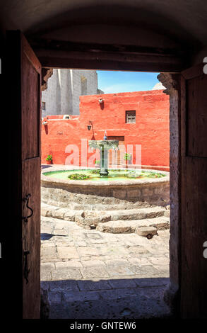 Cour intérieure avec fontaine, Couvent Santa Catalina à Arequipa, Pérou, vu à travers une porte sur une journée ensoleillée avec ciel bleu Banque D'Images