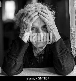 Triste femme âgée est titulaire d'une tête. Photo en noir et blanc. Banque D'Images