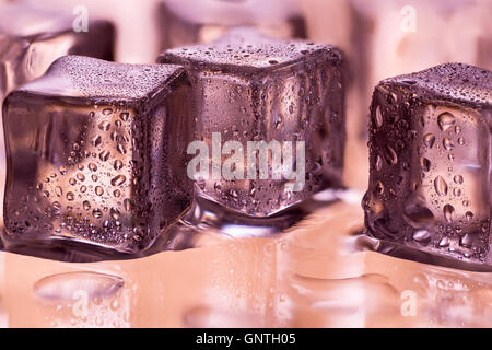 Cubes de glace transparente de fusion avec gouttes d'eau sur le verre humide Banque D'Images