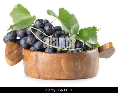 Les raisins violets dans la plaque en bois isolé sur le fond blanc. Banque D'Images