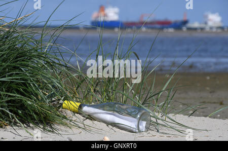 Une lettre dans une bouteille se trouve sur la plage, sur l'île de conservation des oiseaux de l'Scharhoern, Allemagne, 01 septembre 2016. Environ 40 représentants de l'organisation de protection de l'environnement sont la collecte des déchets en plastique et autres déchets sur les îles de conservation des oiseaux d'Scharhoern Nigehoern, et qui sinon sont seulement accessibles aux gardes ornithologique, dans le cadre de leur action "faire de vagues pour protéger les mers." Photo : CARMEN JASPERSEN/dpa Banque D'Images